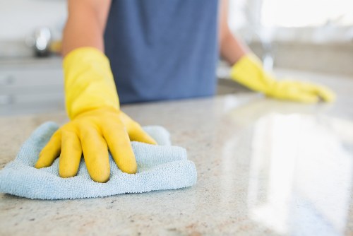Cleaning operative applying health and safety controls in a work area